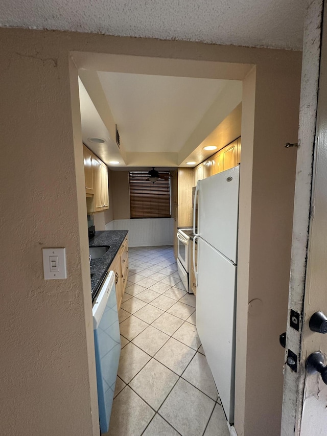 kitchen with light tile patterned floors, white appliances, and sink