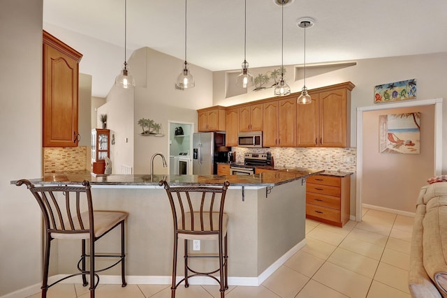 kitchen with decorative backsplash, appliances with stainless steel finishes, a breakfast bar area, and vaulted ceiling