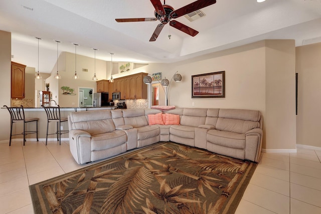 tiled living room with ceiling fan and high vaulted ceiling