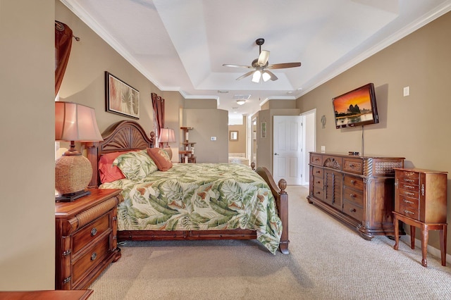 carpeted bedroom featuring ceiling fan, ornamental molding, and a raised ceiling