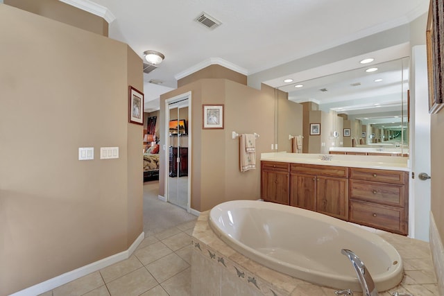 bathroom featuring vanity, ornamental molding, tile patterned floors, and a relaxing tiled tub