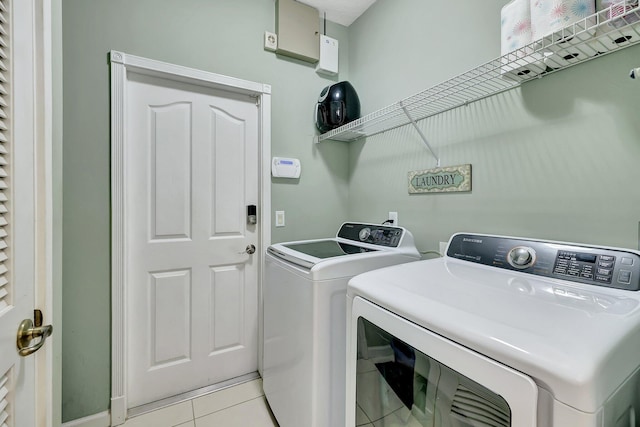 laundry area with light tile patterned floors and washing machine and clothes dryer