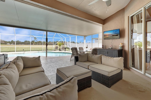 sunroom / solarium featuring ceiling fan and a pool