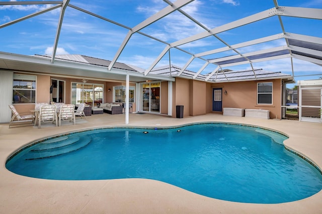 view of swimming pool featuring an outdoor hangout area, glass enclosure, and a patio area