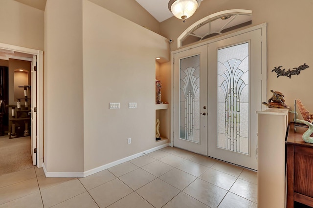 entrance foyer featuring light tile patterned floors, french doors, and vaulted ceiling