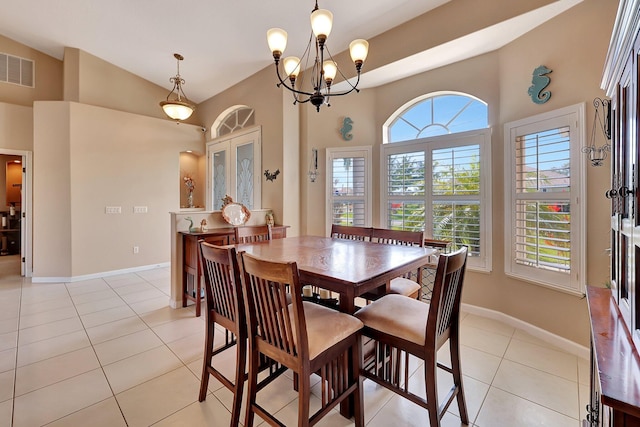 dining space with vaulted ceiling, light tile patterned flooring, and a chandelier