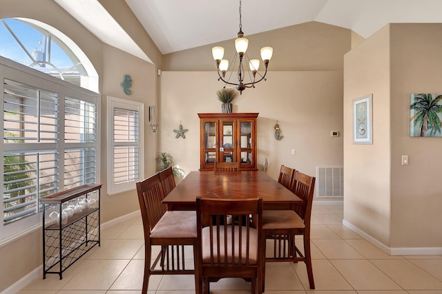 tiled dining area featuring vaulted ceiling and a chandelier