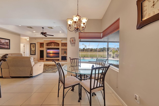 tiled dining room with ceiling fan with notable chandelier and built in features