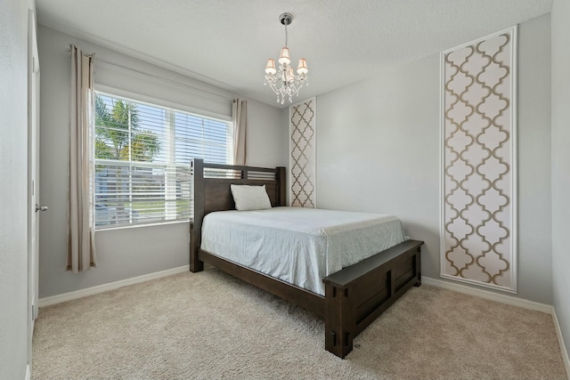 carpeted bedroom featuring a textured ceiling and a chandelier