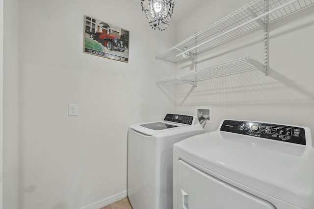 laundry room with independent washer and dryer and an inviting chandelier