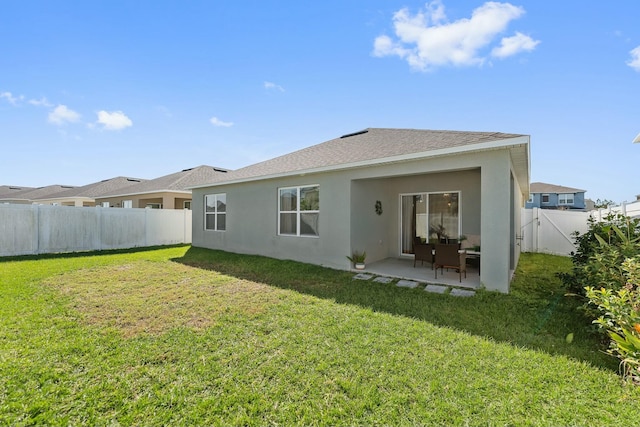 back of property with a patio area and a yard