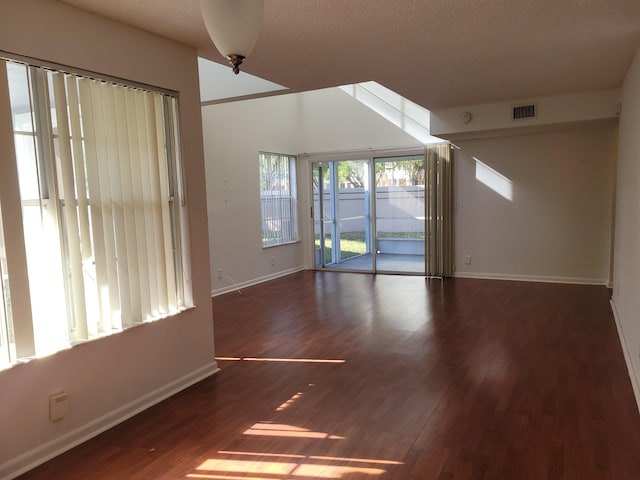 unfurnished room featuring a textured ceiling and dark wood-type flooring