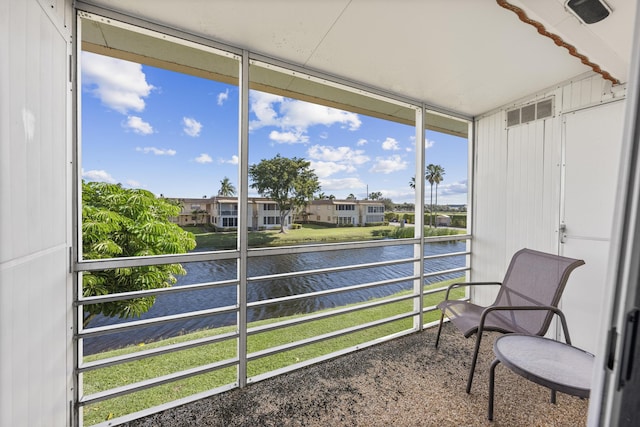 sunroom featuring a water view