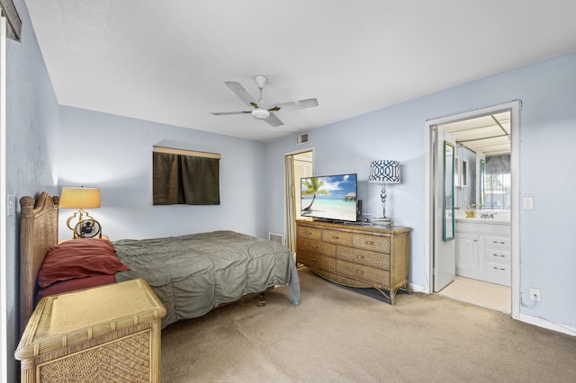 bedroom featuring light carpet, connected bathroom, and ceiling fan