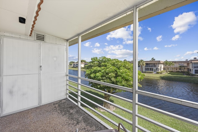 unfurnished sunroom featuring a water view