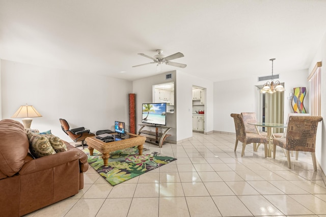 tiled living room featuring ceiling fan with notable chandelier