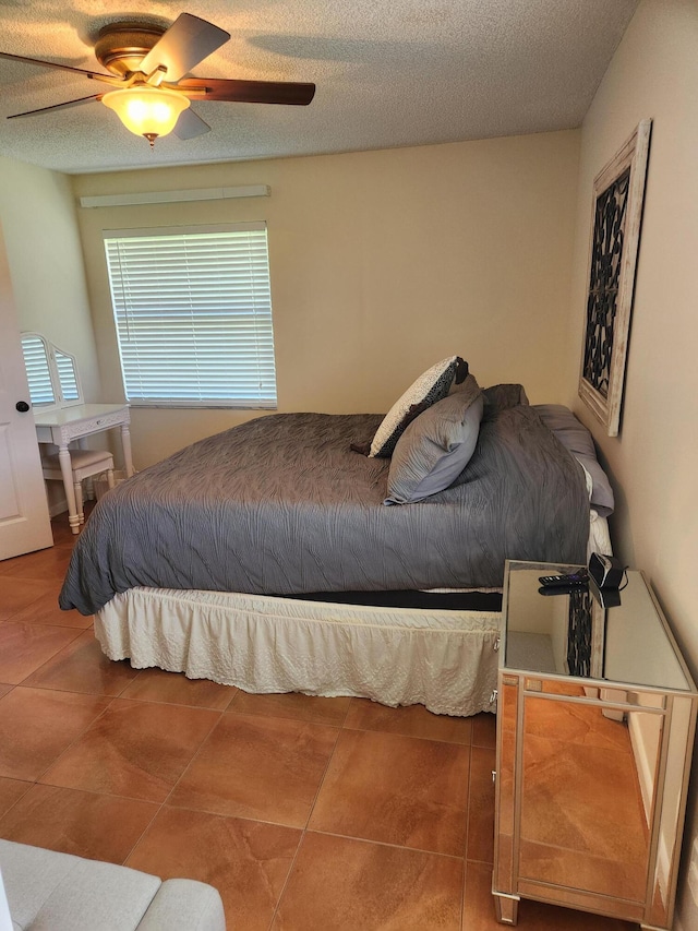 tiled bedroom featuring a textured ceiling and ceiling fan