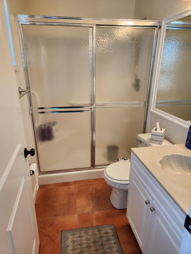 bathroom featuring tile patterned flooring, vanity, toilet, and an enclosed shower