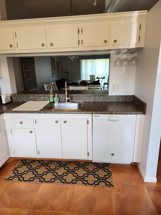 kitchen featuring white dishwasher, light tile patterned flooring, white cabinets, and sink