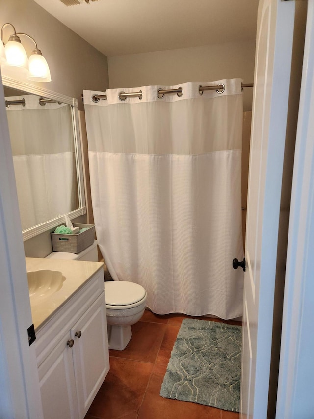 bathroom with toilet, vanity, and tile patterned floors