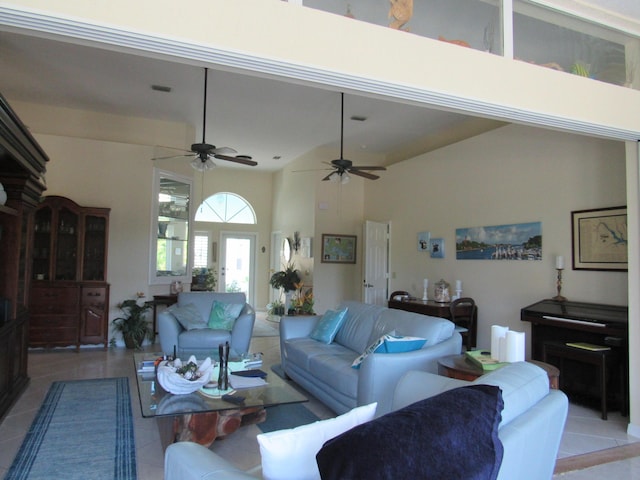 living room featuring light tile patterned floors, ceiling fan, and a high ceiling