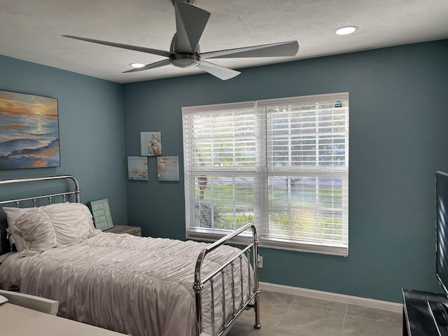 tiled bedroom featuring ceiling fan