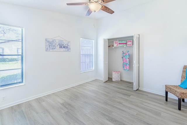 unfurnished bedroom featuring ceiling fan, a closet, multiple windows, and light hardwood / wood-style flooring