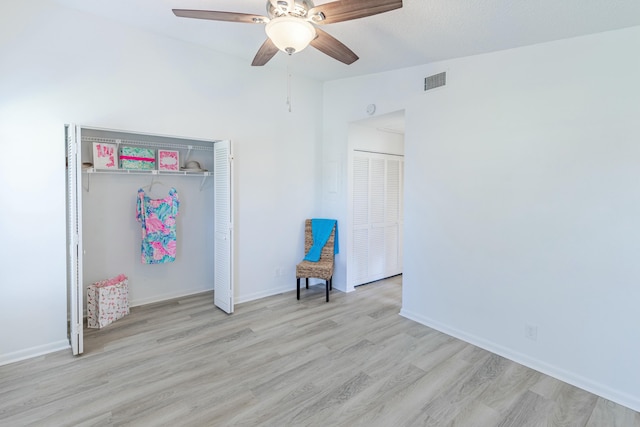 unfurnished bedroom featuring light wood-type flooring, ceiling fan, and a closet