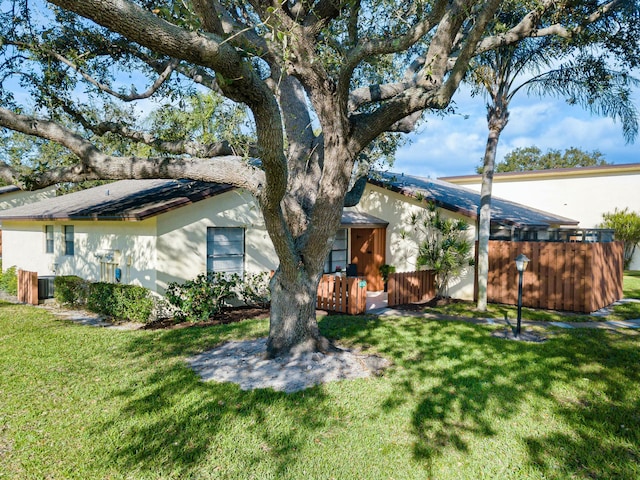 view of front of home with central AC and a front yard