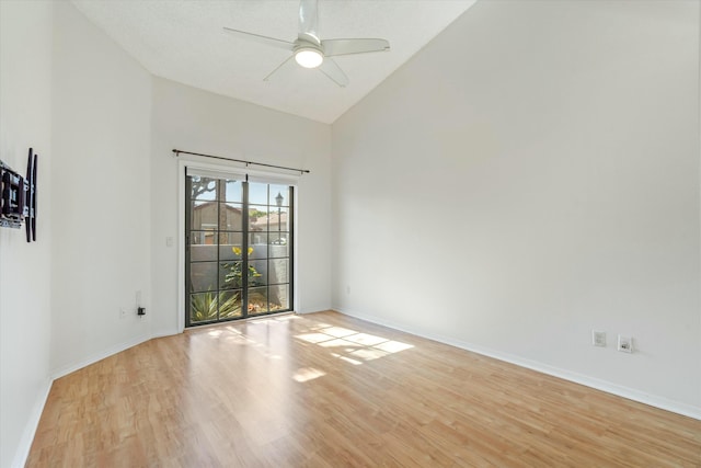 empty room featuring ceiling fan, high vaulted ceiling, and light wood-type flooring