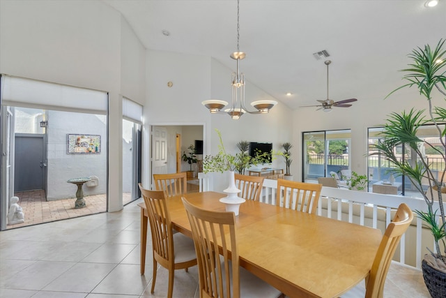 dining area featuring light tile patterned floors, high vaulted ceiling, and ceiling fan with notable chandelier