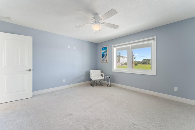 unfurnished room featuring a textured ceiling, ceiling fan, and light colored carpet