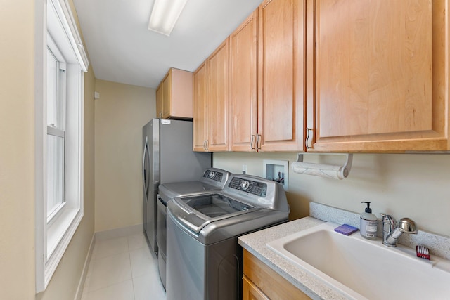 laundry room featuring sink, cabinets, and washer and clothes dryer