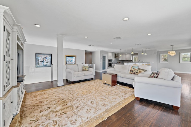 living room featuring dark wood-type flooring and an inviting chandelier