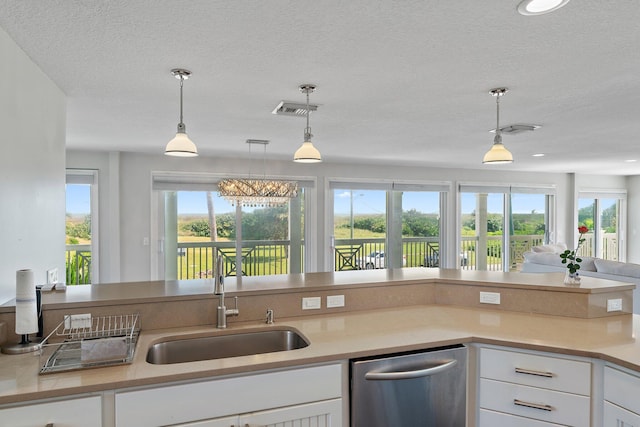 kitchen featuring sink, white cabinets, a textured ceiling, decorative light fixtures, and dishwasher