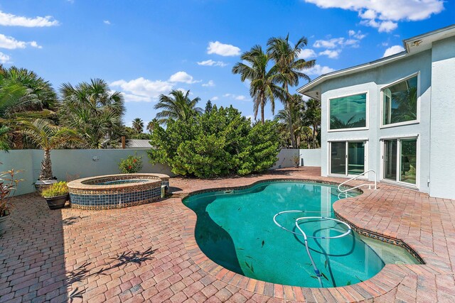 view of pool with a patio and an in ground hot tub