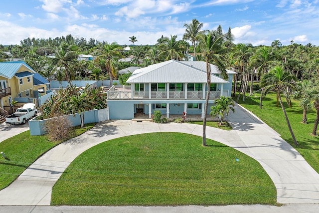 view of front of house with a balcony and a front yard