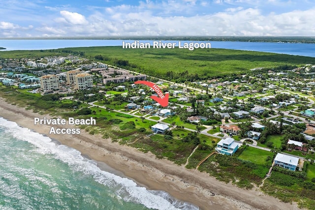 birds eye view of property featuring a beach view and a water view