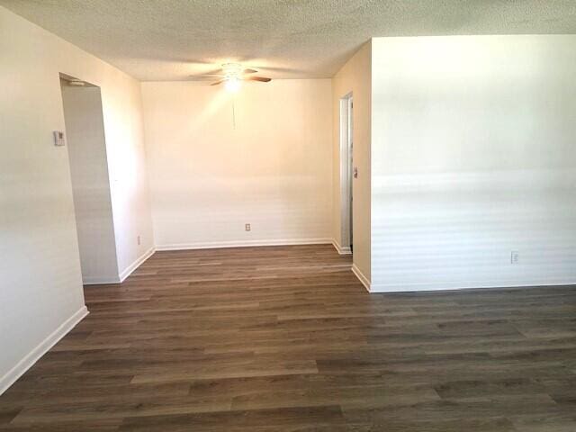 spare room featuring a textured ceiling, ceiling fan, and dark wood-type flooring