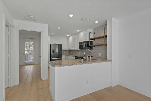 kitchen with white cabinetry, sink, tasteful backsplash, stainless steel refrigerator with ice dispenser, and kitchen peninsula