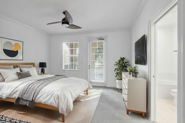 carpeted bedroom featuring access to exterior, ensuite bath, ceiling fan, and ornamental molding