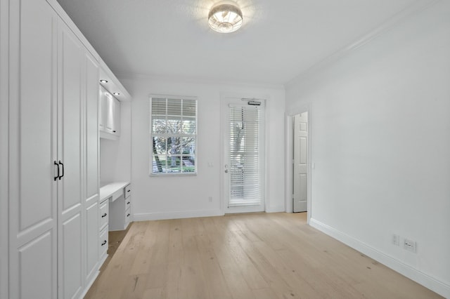 interior space featuring light wood-type flooring and ornamental molding