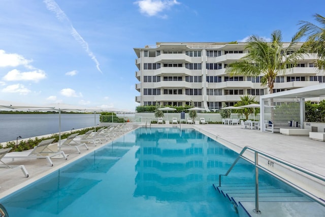 view of pool with a water view and a patio area