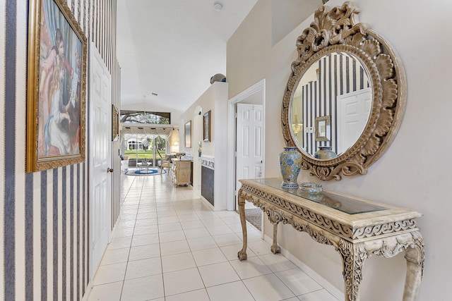 corridor featuring light tile patterned floors and lofted ceiling