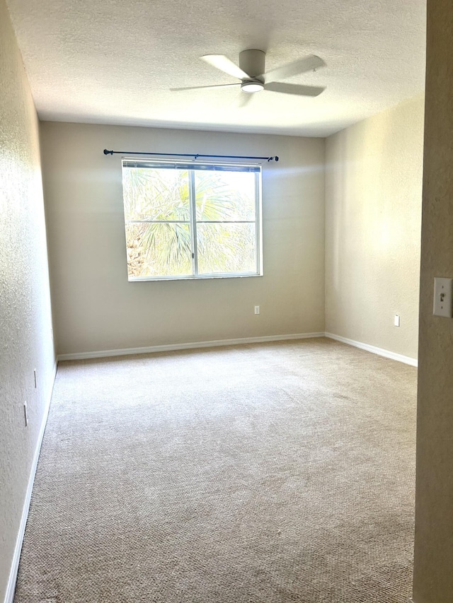 spare room with ceiling fan, a textured ceiling, and carpet