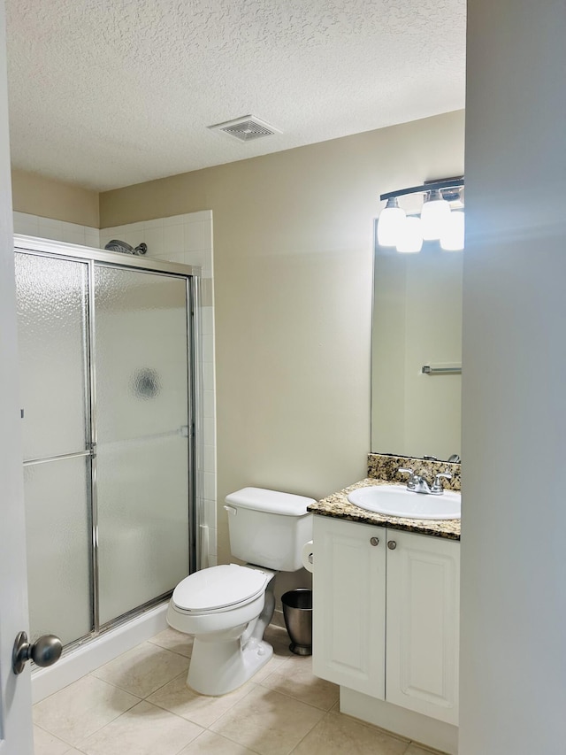 bathroom with a shower with door, vanity, tile patterned floors, and a textured ceiling