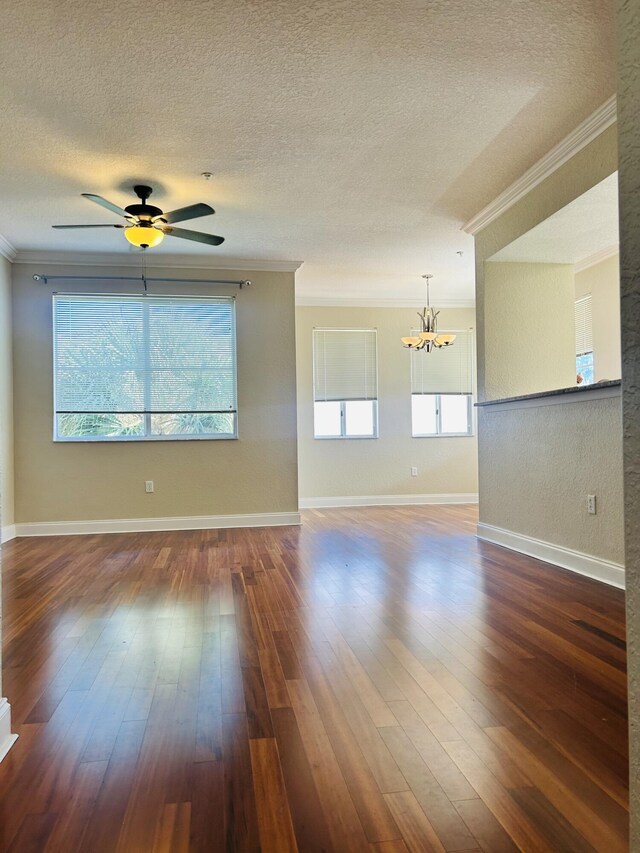 living room with a textured ceiling, ceiling fan with notable chandelier, dark hardwood / wood-style floors, and ornamental molding