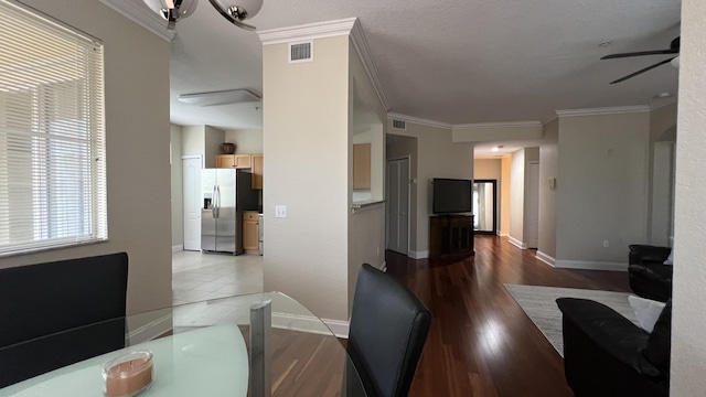 dining room featuring crown molding, light hardwood / wood-style floors, and ceiling fan with notable chandelier