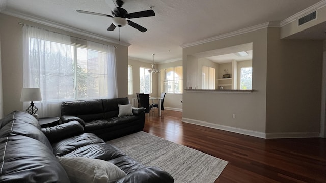 living room featuring crown molding, ceiling fan with notable chandelier, dark hardwood / wood-style floors, and a textured ceiling