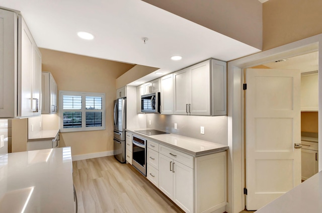 kitchen with light hardwood / wood-style flooring, white cabinets, and appliances with stainless steel finishes